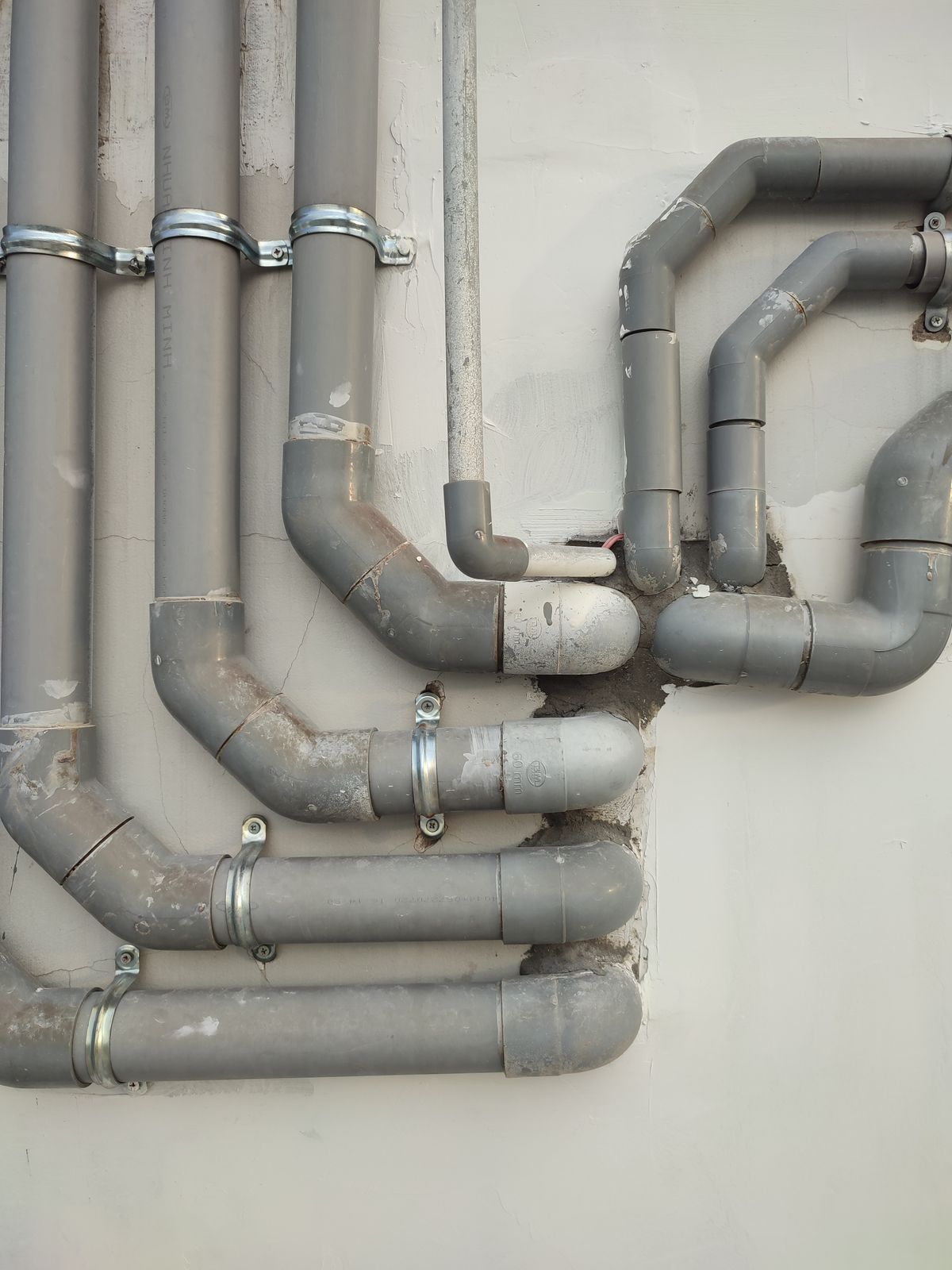 Sfeerbeeld van een loodgieter aan het werk met industriële leidingen